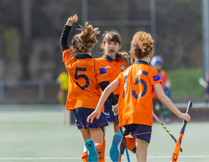 Infants jugant a hoquei herba